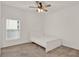 Simple bedroom with a white bed frame, plush carpet, and a window at 4180 Bull St, St Cloud, FL 34772