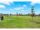 Community green space features manicured lawn with walking path and playground in the distance at 4180 Bull St, St Cloud, FL 34772