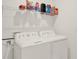 Functional laundry room boasts modern white washer and dryer with wire rack shelving above for storage at 4180 Bull St, St Cloud, FL 34772