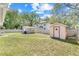 Spacious backyard featuring two storage sheds, a well-maintained lawn, and privacy fence at 449 Martigues Drive, Kissimmee, FL 34759