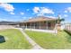 Exterior view of a screened-in porch that overlooks a large, fenced-in yard at 449 Martigues Drive, Kissimmee, FL 34759