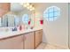 Bright bathroom featuring a double vanity, octagon window, and separate shower stall at 449 Martigues Drive, Kissimmee, FL 34759