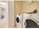 Bright laundry room featuring tile flooring, modern washer and dryer, and closet space at 449 Martigues Drive, Kissimmee, FL 34759