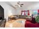 Spacious living room featuring a large sectional sofa, entertainment center, and tile flooring at 449 Martigues Drive, Kissimmee, FL 34759