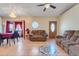 A spacious living room featuring tile flooring, ample seating, large windows, and a chandelier at 449 Martigues Drive, Kissimmee, FL 34759