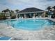 Community pool with a recreation building, featuring poolside seating and beautiful landscaping at 4778 Cragmere Loop, Clermont, FL 34711