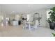 Bright dining room with white wood flooring, complemented by an open kitchen and large decorative mirror at 4778 Cragmere Loop, Clermont, FL 34711