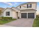Two-story home with a two-car garage, brick driveway, manicured landscaping, and neutral exterior at 4778 Cragmere Loop, Clermont, FL 34711