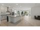 Spacious kitchen with granite countertops, stainless steel appliances, flowing into dining and living areas at 4778 Cragmere Loop, Clermont, FL 34711