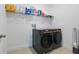Laundry room featuring black front loading washer and dryer and ample shelving at 4778 Cragmere Loop, Clermont, FL 34711