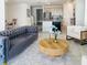 Bright living room featuring a plush couch, round wood table, and an open-concept layout to kitchen and dining area at 4778 Cragmere Loop, Clermont, FL 34711