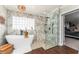 Elegant bathroom boasting a soaking tub, walk-in shower, and marble tile details at 5011 Dorian Ave, Belle Isle, FL 32812