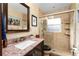 Updated bathroom with a glass-enclosed shower, granite countertop, and neutral tile flooring at 5011 Dorian Ave, Belle Isle, FL 32812