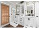 Elegant bathroom featuring double vanities with dark fixtures and decorative mirrors and tile at 5011 Dorian Ave, Belle Isle, FL 32812
