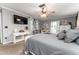 Comfortable main bedroom with ceiling fan, TV, ensuite bathroom, and neutral gray color palette at 5011 Dorian Ave, Belle Isle, FL 32812