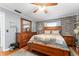 Spacious main bedroom with a queen-size bed, hardwood floors, and a decorative brick accent wall at 5011 Dorian Ave, Belle Isle, FL 32812