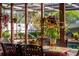 Outdoor dining area with views of the pool, hanging plants, and a screened enclosure at 5011 Dorian Ave, Belle Isle, FL 32812