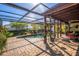 Beautiful pool with brick pavers, screened enclosure, and an outdoor dining area at 5011 Dorian Ave, Belle Isle, FL 32812