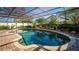 Sparkling pool in screened enclosure, bordered by brick pavers and landscaped foliage at 5011 Dorian Ave, Belle Isle, FL 32812