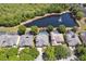 Aerial view showcases homes with screened pools and a scenic pond with fountain, surrounded by verdant trees at 5619 Bear Stone Run, Oviedo, FL 32765