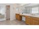 Bright bathroom with dual sinks, shower, large mirror and tiled floor at 5619 Bear Stone Run, Oviedo, FL 32765