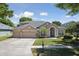 Charming single Gathering home featuring a three-car garage, manicured lawn, and inviting entrance at 5619 Bear Stone Run, Oviedo, FL 32765