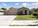 Charming single-Gathering home with a three-car garage, manicured lawn, and inviting front entrance at 5619 Bear Stone Run, Oviedo, FL 32765
