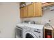Well-lit laundry area features updated appliances and ample storage with above-washer cabinets for convenience at 5619 Bear Stone Run, Oviedo, FL 32765
