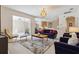 Inviting living room with plush seating, stylish chandelier, and sliding glass doors to outdoor space at 5619 Bear Stone Run, Oviedo, FL 32765