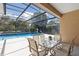 Screened patio boasts a lovely outdoor dining set and views of the inviting pool and natural landscape at 5619 Bear Stone Run, Oviedo, FL 32765