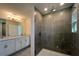Modern bathroom featuring a glass-enclosed shower with tile walls and a double vanity sink at 7028 Rolling Leaf Rd, Groveland, FL 34736