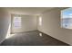 Bright bedroom with plush carpeting and multiple windows, creating a welcoming atmosphere at 7028 Rolling Leaf Rd, Groveland, FL 34736