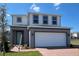 Charming two-story home featuring a two-car garage and a welcoming front entrance on a beautiful, sunny day at 7028 Rolling Leaf Rd, Groveland, FL 34736