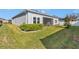 Lush backyard featuring green lawn, manicured hedges, and gray home exterior at 7369 Sw 77Th Ave, Ocala, FL 34481