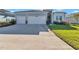 Charming light blue home boasts a wide driveway, a two-car garage, and well-maintained landscaping at 7369 Sw 77Th Ave, Ocala, FL 34481