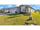Light blue house featuring a two-car garage and a lush green lawn with beautiful landscaping at 7369 Sw 77Th Ave, Ocala, FL 34481