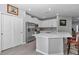 Bright kitchen with white cabinets, stainless appliances, island, and gray tiled floors at 7369 Sw 77Th Ave, Ocala, FL 34481