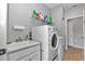 Functional laundry room equipped with modern washer, dryer, sink, and storage shelves at 7369 Sw 77Th Ave, Ocala, FL 34481