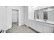Bright bathroom features double sinks with quartz countertops and a doorway to a walk-in closet at 752 Trotters Dr, Eagle Lake, FL 33839