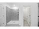Bathroom featuring a walk-in shower with gray tile, and a doorway leading to a separate toilet area at 752 Trotters Dr, Eagle Lake, FL 33839