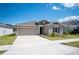 A well-maintained home featuring a neat front yard and a spacious driveway, set against a bright blue sky at 752 Trotters Dr, Eagle Lake, FL 33839