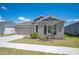 A well-maintained home featuring a neat front yard and a spacious driveway, set against a bright blue sky at 752 Trotters Dr, Eagle Lake, FL 33839