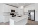 Bright kitchen features white cabinets, stainless steel appliances and a large island with quartz countertops at 752 Trotters Dr, Eagle Lake, FL 33839