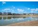 Scenic view of a tranquil pond reflecting nearby homes under a partly cloudy sky at 752 Trotters Dr, Eagle Lake, FL 33839