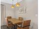Dining room with a modern table, four chairs, and stylish pendant lights creating a warm ambiance at 831 Retreat Blvd # 103, Davenport, FL 33897