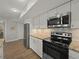 Kitchen with stainless steel appliances, granite countertops, and hardwood floors at 831 Retreat Blvd # 103, Davenport, FL 33897