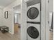 A modern laundry room with stacked washer and dryer units for space saving and convenience at 831 Retreat Blvd # 103, Davenport, FL 33897