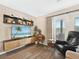 Living room featuring a media center, an accent chair, and a window with blinds at 831 Retreat Blvd # 103, Davenport, FL 33897