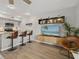Living room features a modern media center, bar seating, and hardwood flooring at 831 Retreat Blvd # 103, Davenport, FL 33897