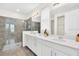 Modern bathroom featuring dual sinks, white cabinetry, and a luxurious glass-enclosed shower at 9033 Flamingo Key Way, Kissimmee, FL 34747